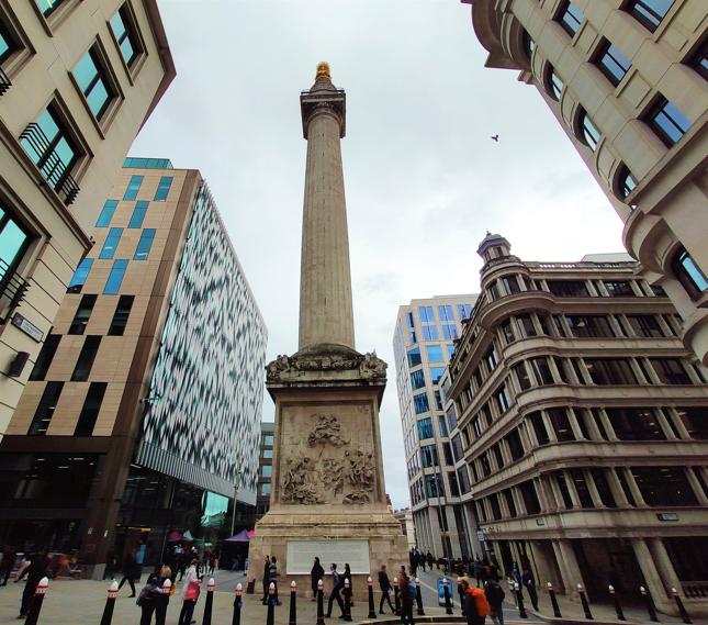 The Monument - pomnik upamiętniający wielki pożar Londynu z 1666 roku. W tle wąskie uliczki City