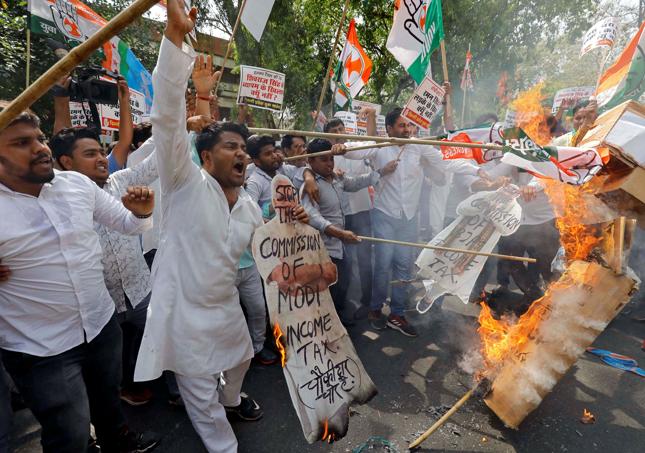 Aktywiście Delhi Pradesh Youth Congress palą podczas protestu wizerunki premiera Narendra Modi oraz szefa rządzącej partii Bharatiya Janata Party - Amita Shaha.