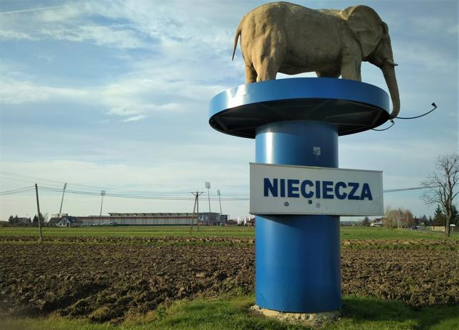 Gdyby nie futbol, o liczącej niewiele ponad 700 mieszkańców Niecieczy mało kto by słyszał. Zespół awansował jednak do ekstraklasy i zaczął przyciągać stadionowych turystów, którzy chcieli na własne oczy zobaczyć, jak wygląda najwyższy poziom ligowy na małopolskiej wsi. Na zdjęciu symbol Niecieczy - słoń, w tle zaś stadion, na którym jeszcze do niedawna gościła Ekstraklasa